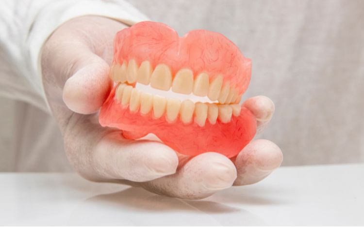 hand holding dentures